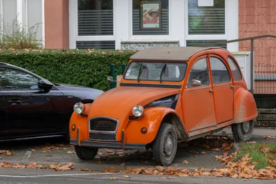 Citroën 2CV orange stationnée en bord de rue