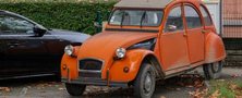 Citroën 2CV orange stationnée en bord de rue